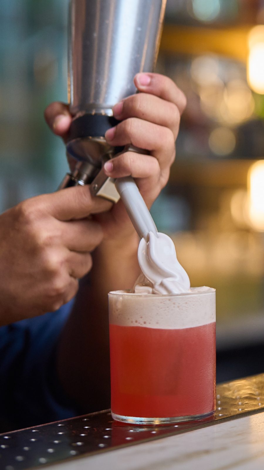 Bartender sirviendo espuma con sifón